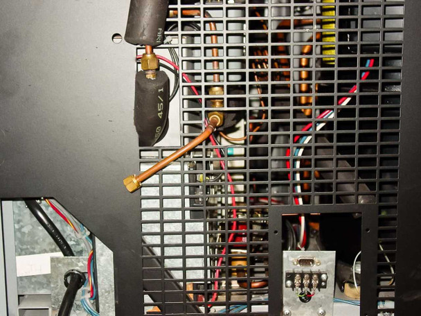 Queue Systems QU2195D12 – close-up of rear refrigeration compartment showing copper tubing, condenser coil, wiring, and DB9 connector bracket