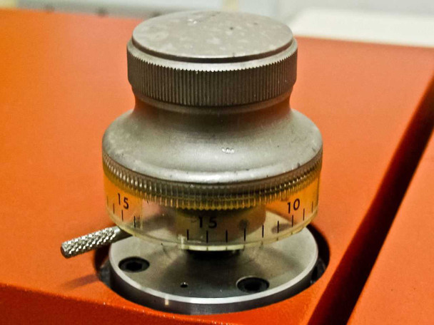 Theta rotation adjustment knob with graduated scale (0–15 range) mounted on orange stage surface