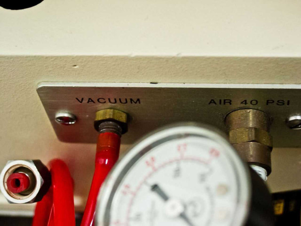 Side pneumatic panel label showing VACUUM port and AIR 40 PSI port with brass fittings and red vacuum hose