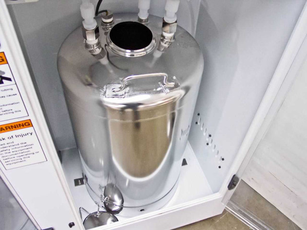 Lower interior view of stainless steel canister inside FSI ChemFill cabinet showing tank body, base, and surrounding cabinet structure