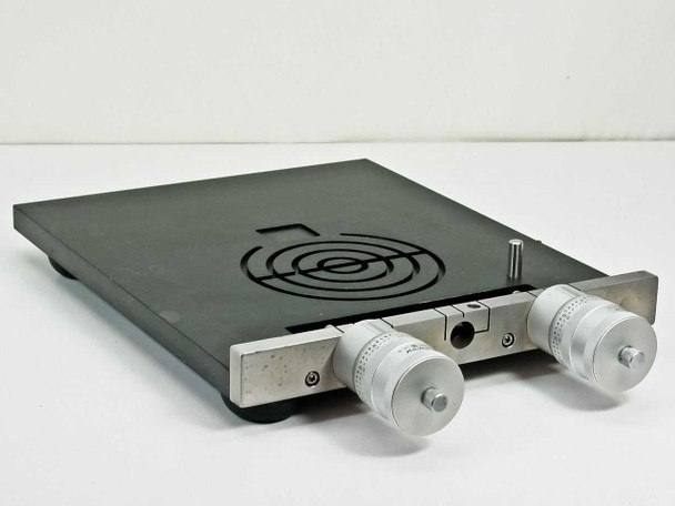 Mitutoyo 197-201 dual micrometer XY stage — front-left 3/4 view showing black anodized platform, spiral groove top surface, and two micrometer heads on front rail
