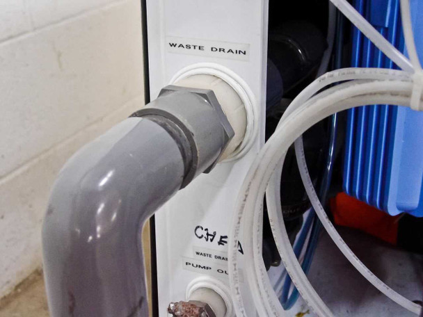 Waste Drain and Chemical connection panel showing gray PVC drain pipe connected to waste drain fitting and blue filter canister