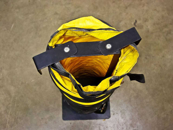 Top-down view looking into the open end of the flexible exhaust duct showing yellow interior and black adjustable strap closure
