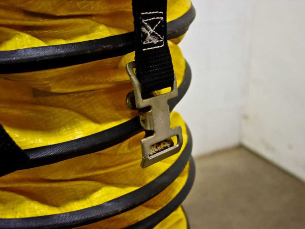 Close-up of adjustable buckle strap on the flexible exhaust duct showing metal quick-release clasp in used condition