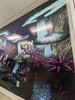 A vibrant wall wrap with intricate designs during the daytime. The wall is well-lit, showcasing the crisp details of the ORAJET® 3930 Photoluminescent Film, which provides enhanced visibility when illuminated.