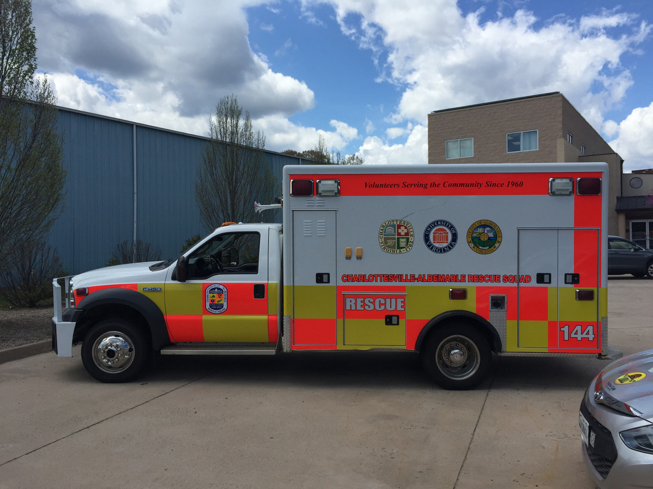 Ambulance with Fluorescent Yellow and Red ORACAL® 7510: A modern ambulance outfitted with a high-visibility design using fluorescent yellow and red vinyl from the ORACAL® 7510 series. The body features bold fluorescent yellow panels along the sides, with fluorescent red chevron stripes on the rear doors for added visibility. The reflective neon colors ensure the vehicle remains noticeable in both daylight and poor lighting, enhancing its emergency response presence. The ambulance's design prioritizes safety and quick recognition, crucial for navigating through busy streets and intersections.