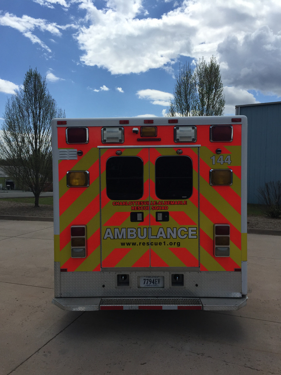 Ambulance with Fluorescent Yellow and Red ORACAL® 7510: A modern ambulance outfitted with a high-visibility design using fluorescent yellow and red vinyl from the ORACAL® 7510 series. The body features bold fluorescent yellow panels along the sides, with fluorescent red chevron stripes on the rear doors for added visibility. The reflective neon colors ensure the vehicle remains noticeable in both daylight and poor lighting, enhancing its emergency response presence. The ambulance's design prioritizes safety and quick recognition, crucial for navigating through busy streets and intersections.