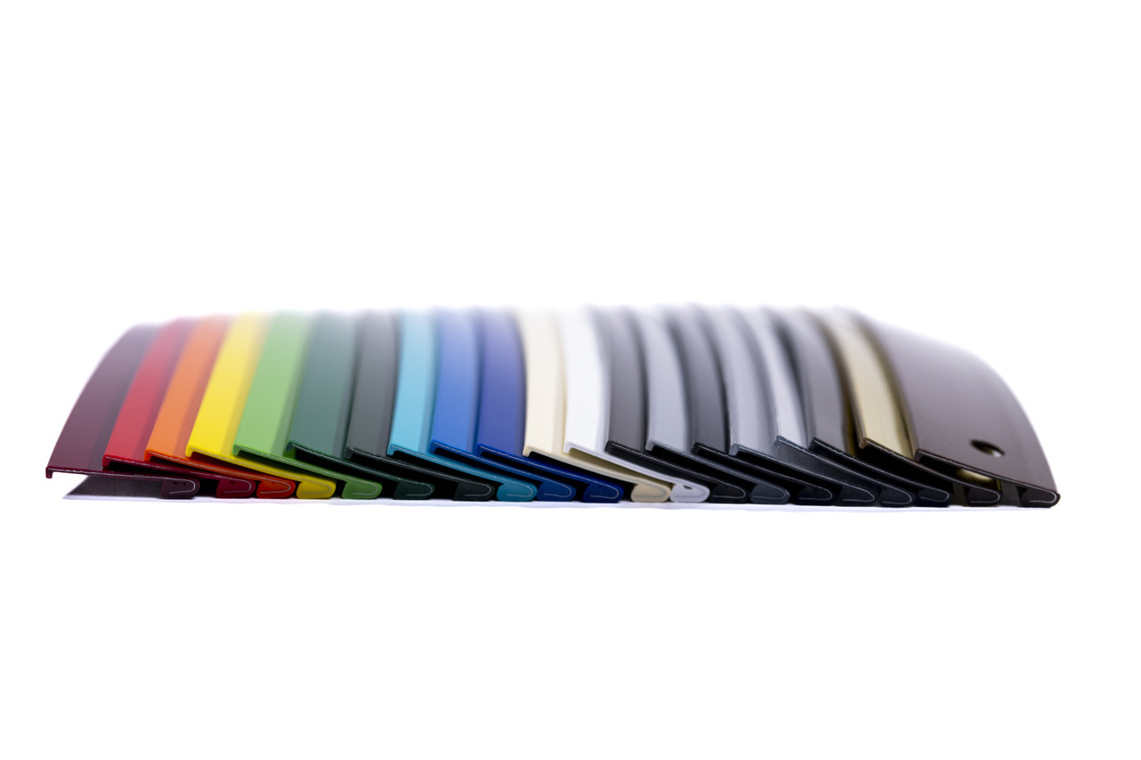 In this image, the Jewelite Trim Cap sample is laid horizontally, offering a detailed view of its overall profile and design features. The photograph clearly captures the trim cap's consistent color, seamless edges, and engineered texture. This perspective demonstrates the cap’s suitability for securely attaching transparent thermoplastic signage faces to lighting enclosures.