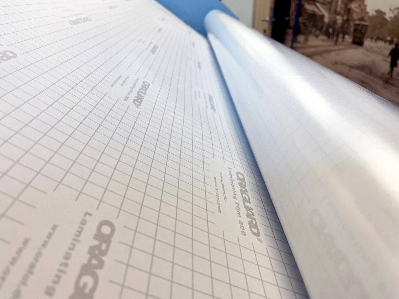 ORAGUARD® 200 Gloss 54" x 150ft roll of 2.5 mil laminating film with a high-gloss finish, ideal for short-term flat digital print protection.