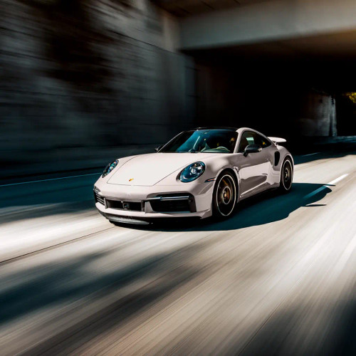 Close-up of ultra-gloss PPF installed on a high-end vehicle hood, reflecting showroom lighting.