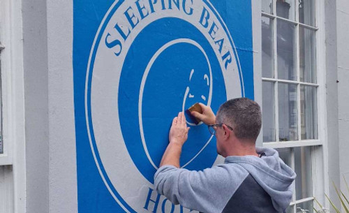 A sheet of Metamark MM-BM stencil film applied to a sign panel, ready for paint application. The blue transparent finish makes cut lines easy to see for accurate alignment and clean paint edges