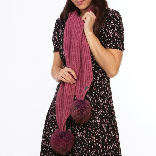 Woman wearing a rose and wildberry coloured Koru merino and possum fur Pom Pom Scarf. Woman wearing a rose and wildberry coloured Koru merino and possum fur Pom Pom Scarf.