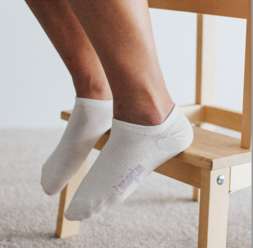 Feet wearing sneaker socks in white  Feet wearing sneaker socks in white
