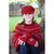 Girl sitting wearing Poncho in colour red.