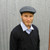 Man wearing blue coloured checkered plaid design, Cheesecutter hat. Man wearing blue coloured checkered plaid design, Cheesecutter hat.