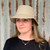 Woman wearing light sand coloured Hydroex rain hat. Woman wearing light sand coloured Hydroex rain hat.
