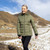 Woman wearing Moke - Lucy Cloud Touch Packable Down Jacket (LUCY) in the colour Olive Green on a hill with snow in the background.