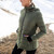 Woman wearing Moke - Lucy Cloud Touch Packable Down Jacket (LUCY) in the colour Olive Green on a hill with snow in the background.