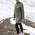 Woman wearing Moke - Sydney Cloud Touch 90/10 Down Coat (SYDNEY) in the colour Olive Green on a hill with snow in the background.