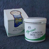 Merino Lanolin Skin Crème with branding on a blanket next to its packaging box.