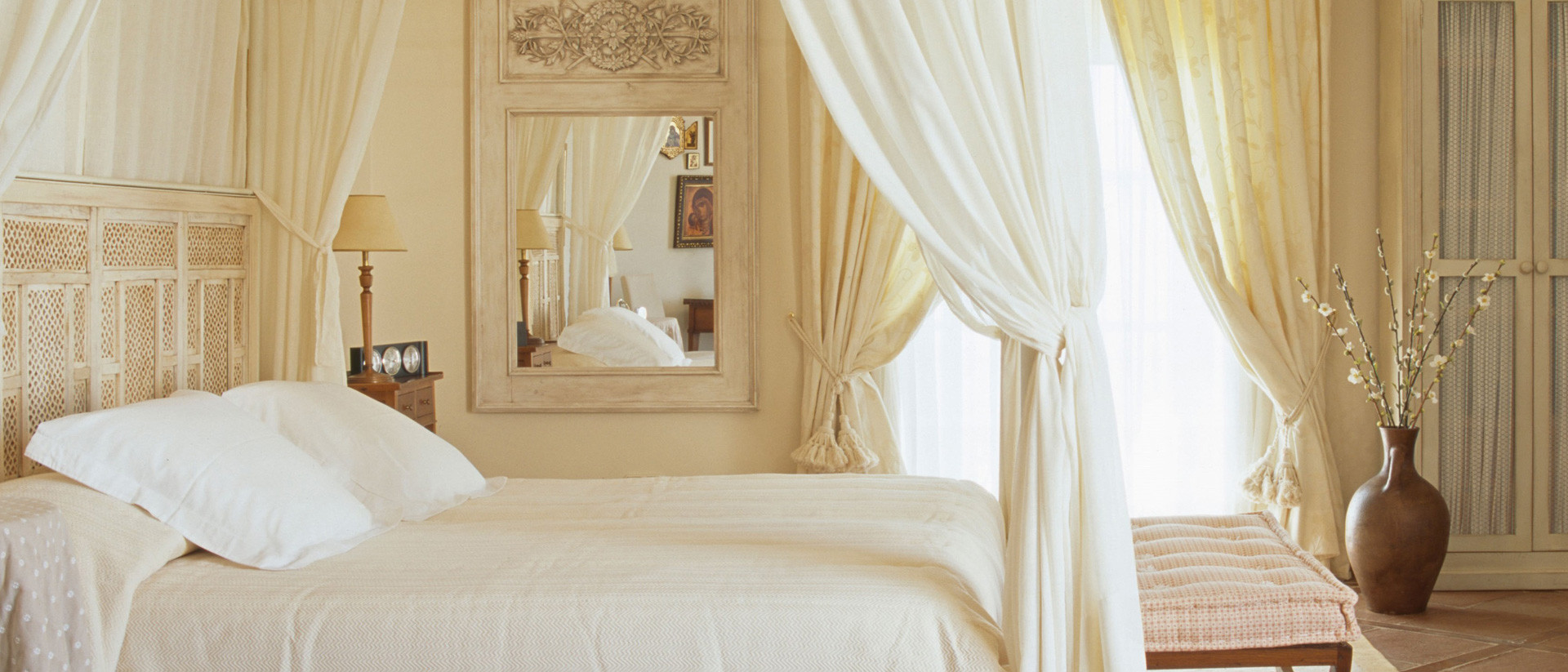 All canopy curtains. Flowing white bed canopy drapes on a four poster bed in an elegant bedroom