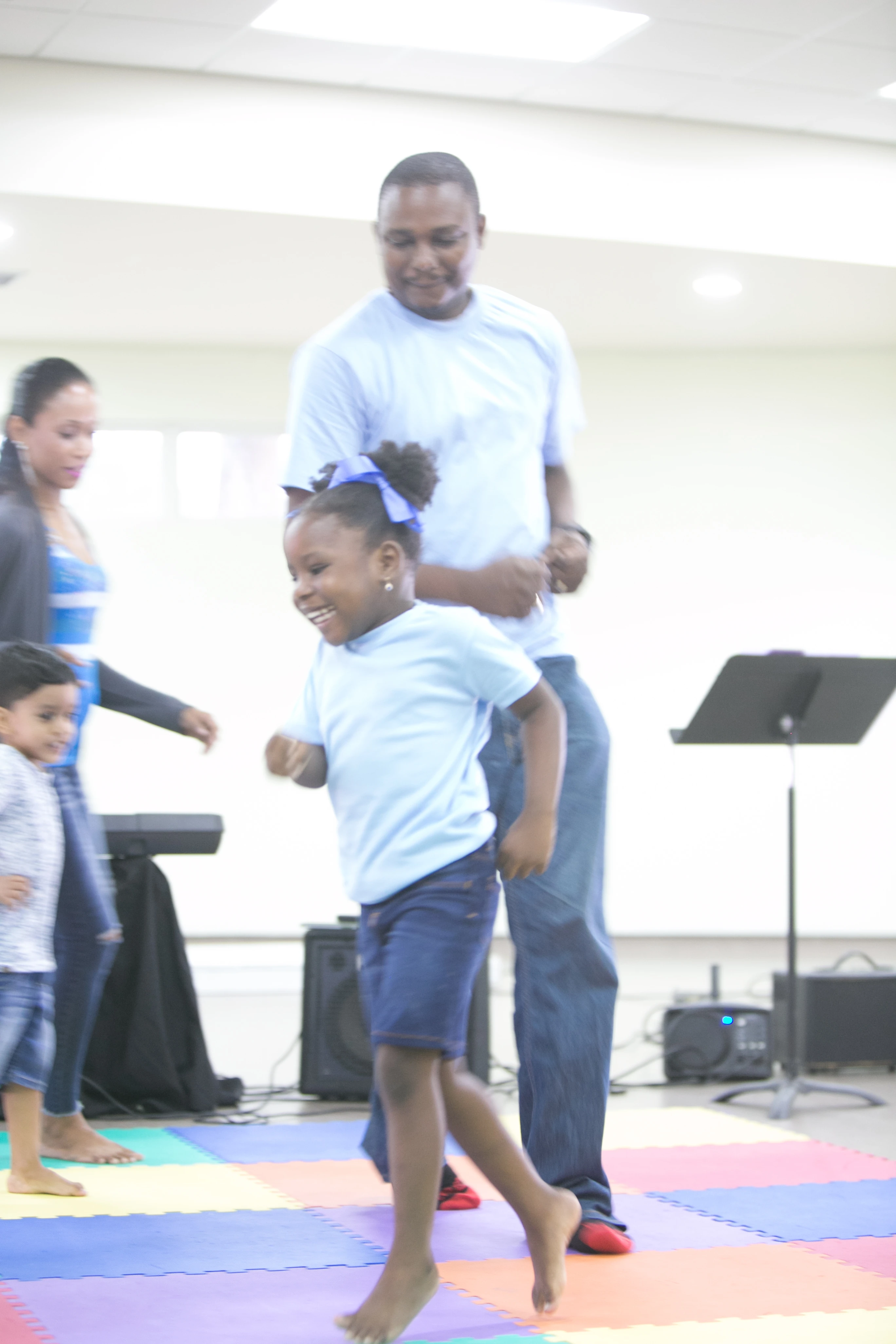 Preschool child moving confidently with parent support in class