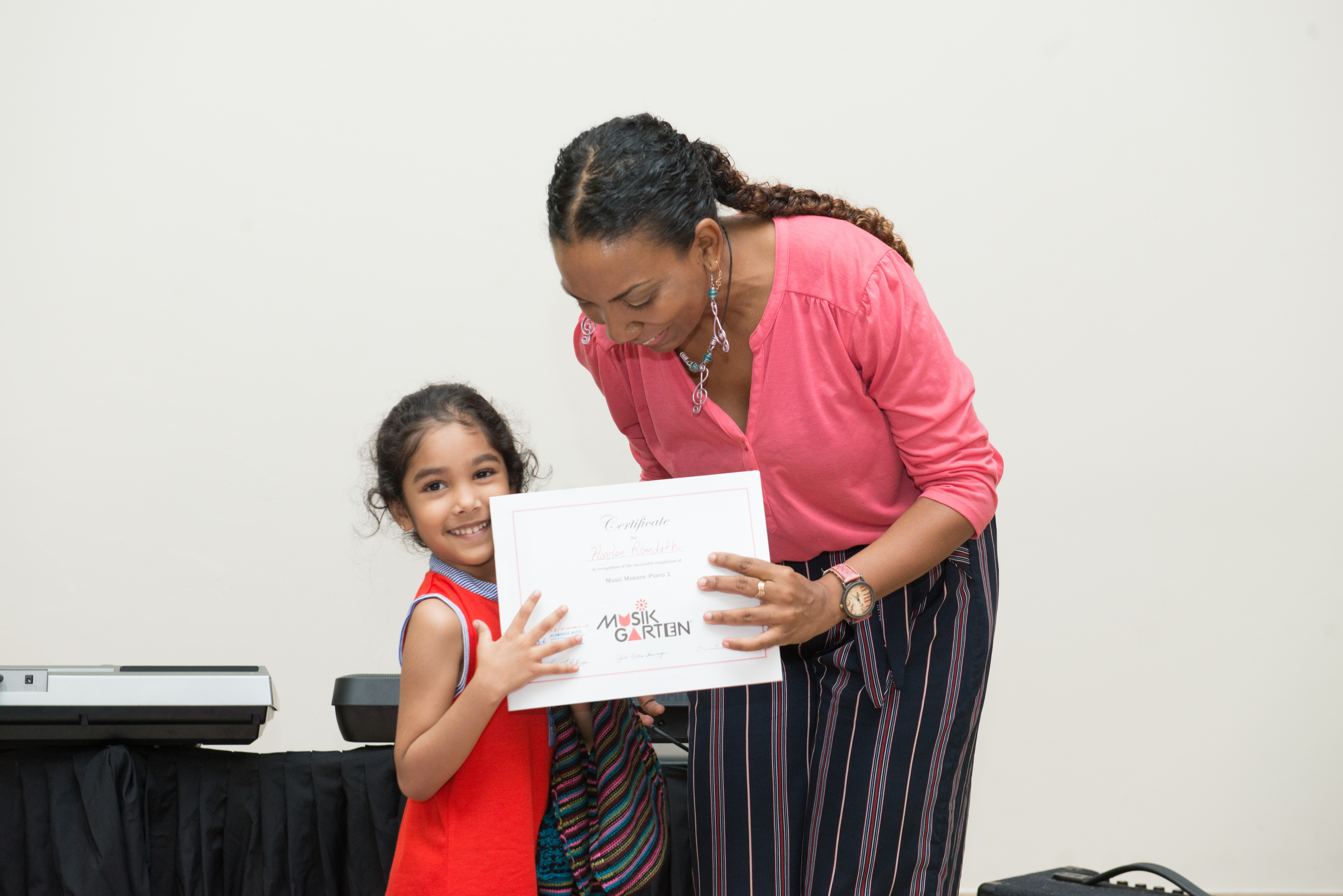 Mrs. Lisa presenting a certificate to a student at Alabanza Music