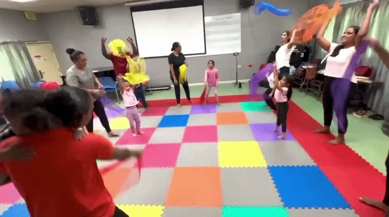 Children and families moving with scarves in an Alabanza MusicVersity class
