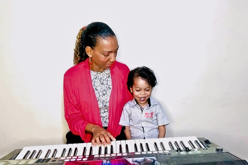Lisa D de Quiñones with her son at the keyboard