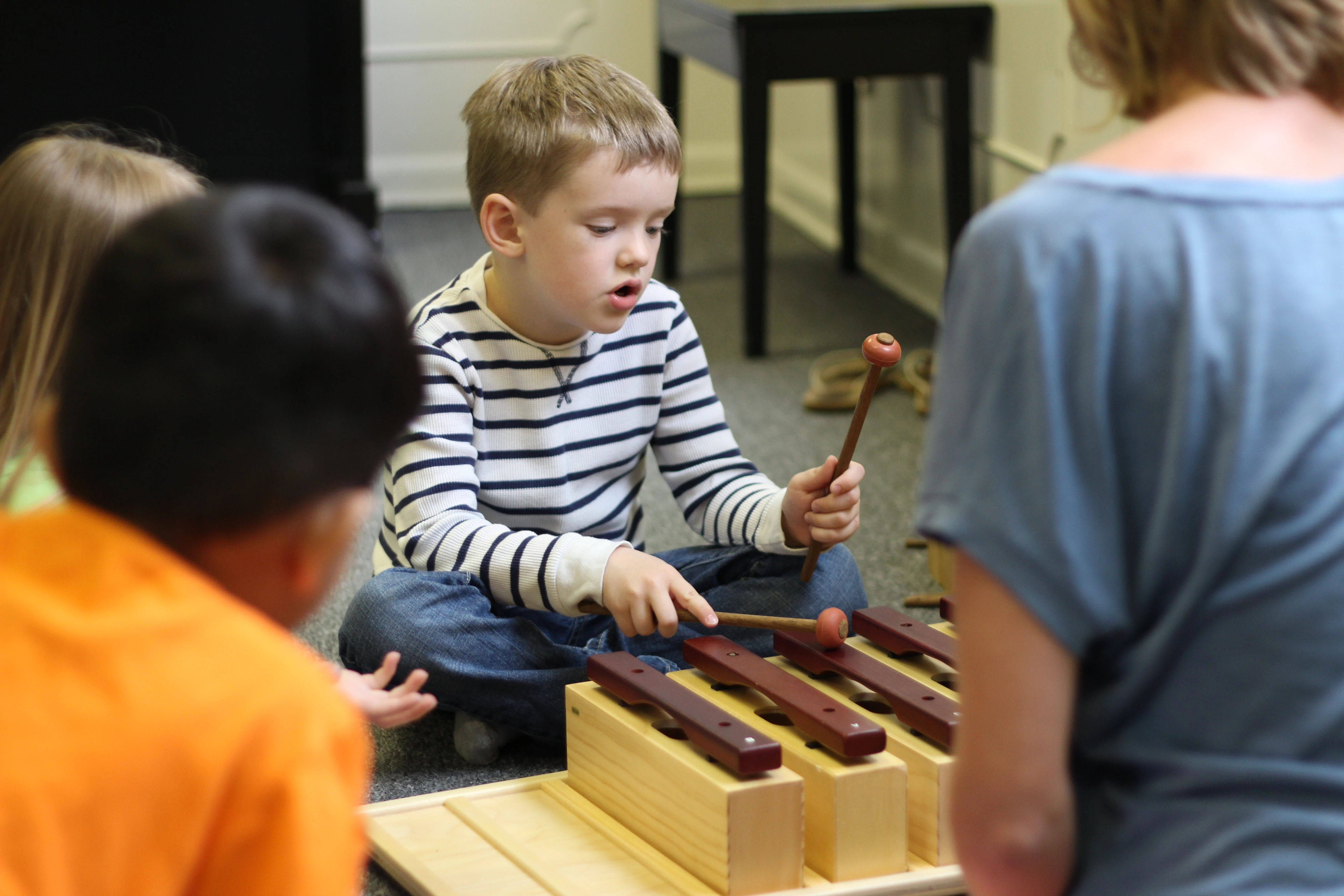 Children and parents working with music notation in a group music class