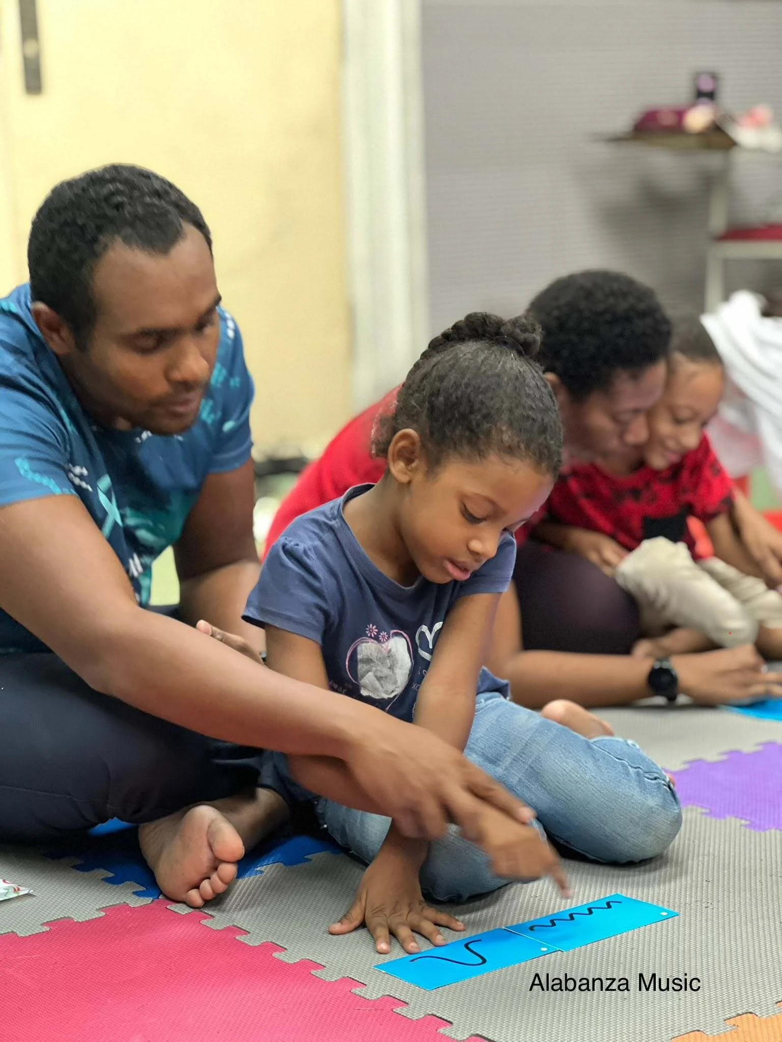 Parent supporting a child with music learning and rhythm activities