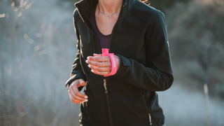 A person holding a neon Sabre branded pepper spray.