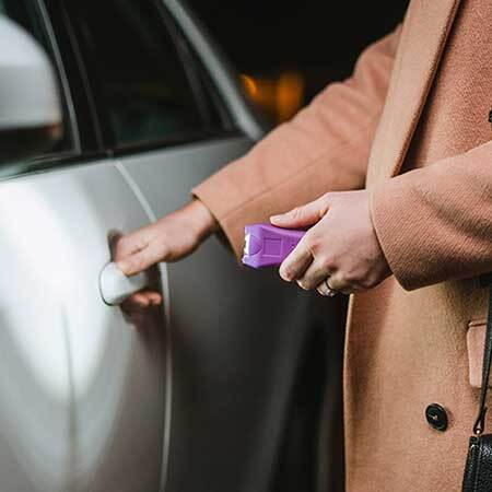 girl holding stun gun to get into car