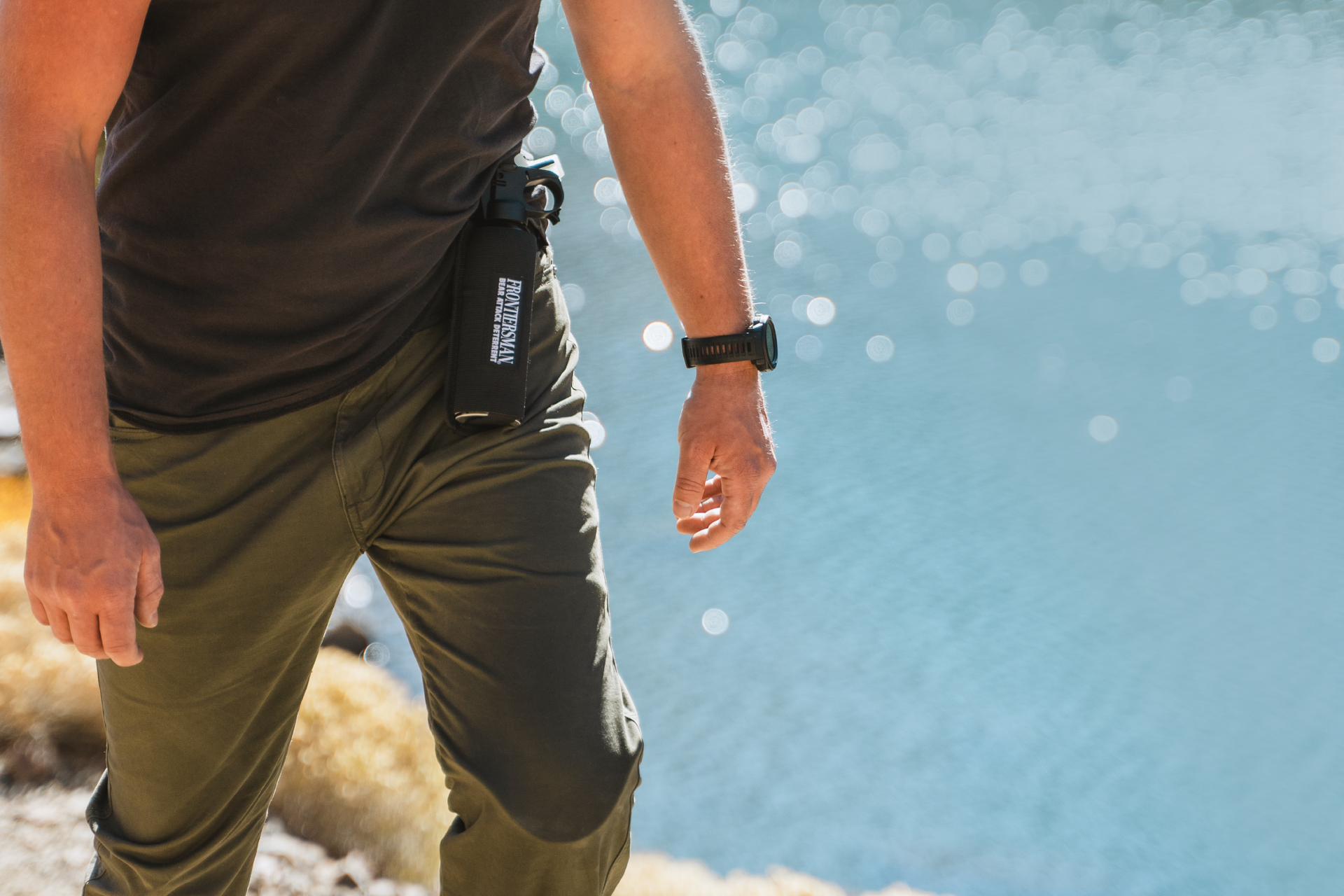 Man hiking with bear spray attached to belt