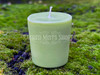 a closeup of one banishing votive candle standing on a bed of moss