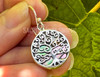 Sterling silver and abalone shell tree of life earrings dangle from French hook ear wires. These earrings are not just a statement of style but also a testament to inner strength, harmony, and spiritual elevation. .