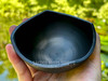 cast iron bowl with rounded wavy edge held on a palm