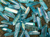 a close up of assorted aqua aura quartz crystal points lying on a rock