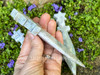 Side view of moss agate athame held between fingers in a cupped hand, showing blade depth and natural patterns. Side view of moss agate athame held between fingers in a cupped hand, showing blade depth and natural patterns.