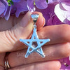 Reverse view of a natural Grape Chalcedony pentagram pendant held in hand, showing the polished .925 sterling silver back, open star design, and stamped bail.