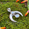 Angled view of sterling silver crescent moon pendant with two smooth Rainbow Moonstone cabochons and articulated hanging stone.