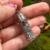 Garnet intention and prayer bottle pendant held in hand to show its approximately 1.25-inch size and detailed silverwork.
