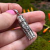 Garnet intention and prayer bottle pendant held in hand to show its approximately 1.25-inch size and detailed silverwork.