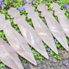 Close view of polished Rose Quartz crystal athames showing pale pink stone, carved blades, and star-shaped handles.