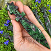 Ruby in Zoisite crystal athame held in hand to show its 5.25 inch size, polished blade, star-shaped handle, and green stone with ruby inclusions.