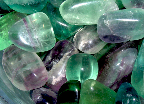 A close-up of an assortment of tumbled rainbow fluorite. Fluorite is ideal for intuition, emotional healing, psychic energies, and purification.