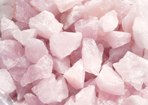 A close-up of rose quartz crystals. Rose quartz is perfect for love, heart chakra, emotional healing, connections, self-love, unconditional love, and compassion.