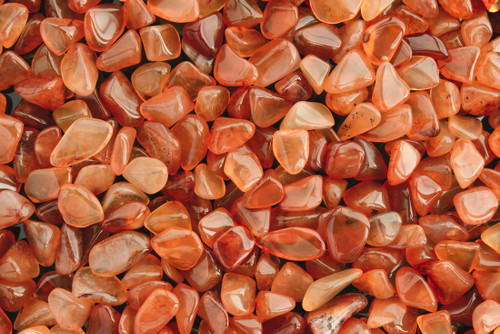 A close-up of an assortment of carnelian gemstones.  Perfect for confidence, vitality, willpower, leadership, meditation, and public speaking.