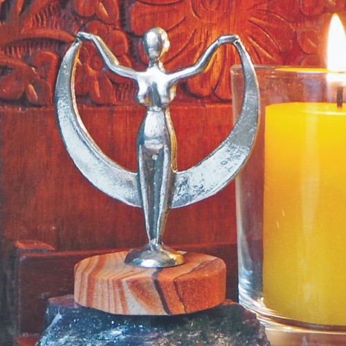 Crescent Moon Pewter Goddess Statuette on Arizona Sandstone standing on stone with a candle next to it.