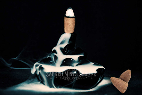 Dragon's Blood Backflow Incense cone burning on a backflow waterfall-style burner.